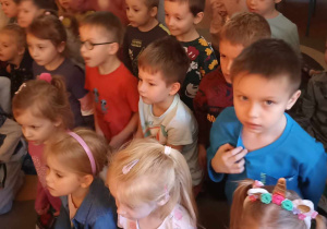 dzieci siedzą na dywanie