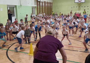 dzieci stoją i trzymają się za kolana