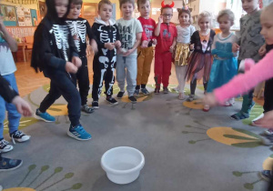 dziewczynka wrzyca pieniążek do miski z wodą
