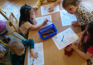 Dzieci wykonują zadanie przy stolikach
