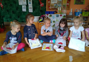 Dzieci trzymają kartki z narysowanym zębem