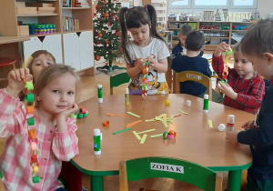 Dzieci wykonują łańcuch na choinkę