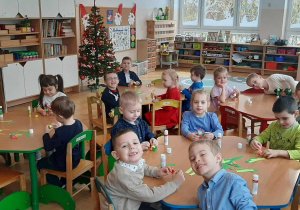 Dzieci wykonują łańcuch na choinkę