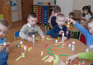 Dzieci wykonują łańcuch na choinkę