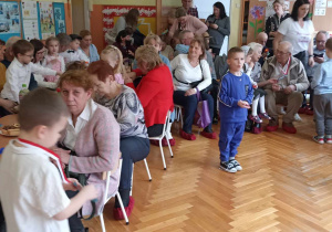 babcie i dziadkowie siedzą ze swoimi wnukami