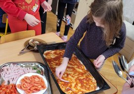 Dzieci układają skłądniki na pizzy