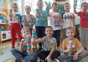 dzieci stoją i trzymają wykonane przez siebie grzechotki