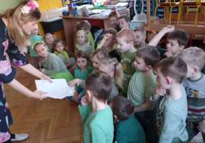 dzieci sięgają kartkę