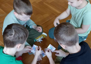 chłopcy trzymaja kartki