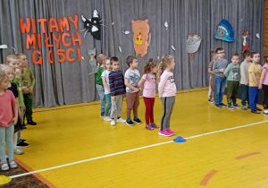 dzieci siedzą w rzędach