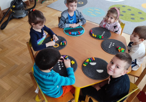 Dzieci liczą przy stolikach