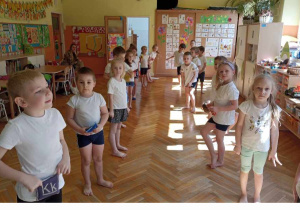 dzieci w kostiumach ćwiczą z woreczkami