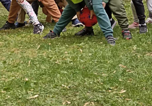 dzieci stoją w rzędzie i podaja sobie piłkę