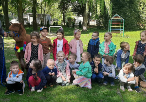 dzieci pozują do zdjęcia z alpakami