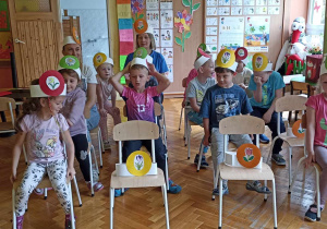 dzieci siedzą na krzesełkach