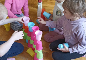 dzieci budują z kolorowych kubeczków