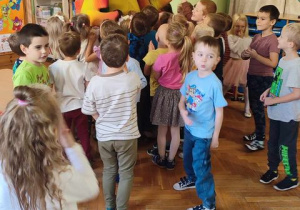 dzieci przytulają się do wielkiej papugi