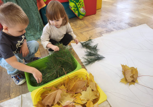 Dzieci układają obrazki z naturalnych materiałów