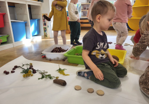Dzieci układają obrazki z naturalnych materiałów