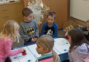 dzieci siedzą na dywanie