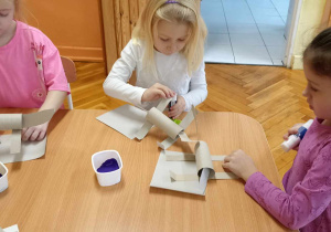 dzieci malują dinozaury z tektury