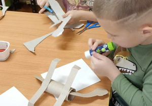 dzieci malują dinozaury z tektury