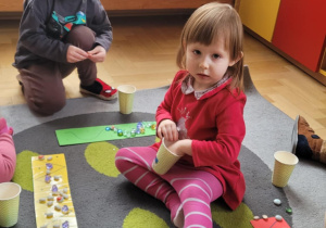 Dzieci układają ścieżki Jasia i Małgosi z kamyczków