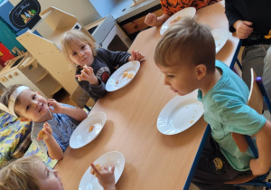 Dzieci jedzą pizzę