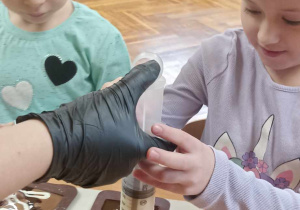 dzieci wciskają ze strzykawki czekoladę do foremek