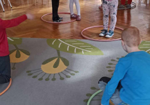 dzieci stoją na dywanie w hula hop