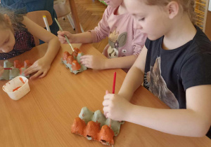 dzieci malują pojemnik po jajkach