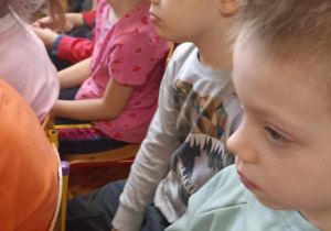 dzieci siedzą na krzesełkach