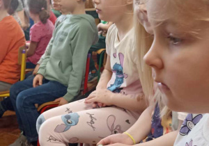 dzieci siedzą na krzesełkach