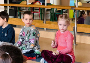 dzieci siedzą na podłodze
