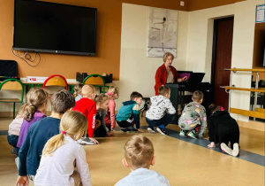 dzieci siedzą na podłodze