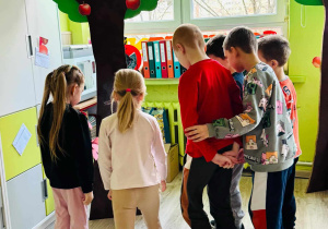 dzieci stoją przy jabłoni