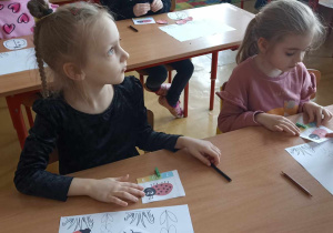 dzieci siedzą w ławce