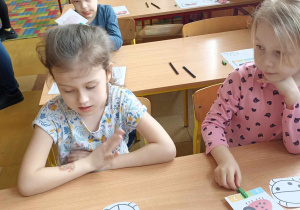 dzieci siedzą w ławce