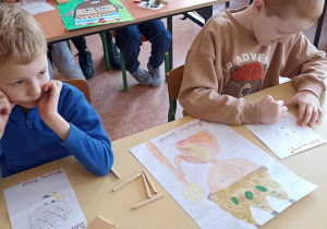 dzieci siedzą w ławce