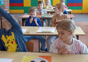 dzieci siedzą w ławce