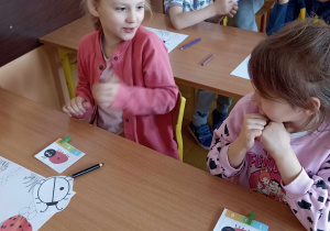 dzieci siedzą w ławce