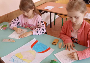 dzieci siedzą w ławce