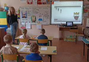 dzieci siedzą w ławce