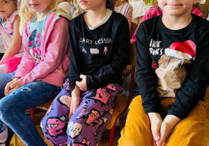 dzieci siedzą na krzesełkach