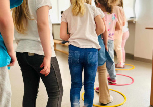 dzieci przeskakują przez hula hop