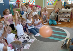 dzieci siedzą na dywanie