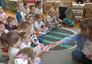 dzieci siedzą na dywanie