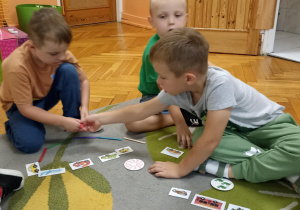 dzieci siedzą na dywanie i liczą