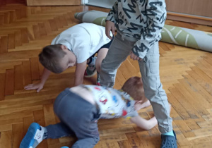 dzieci siedzą na podłodze i ćwiczą