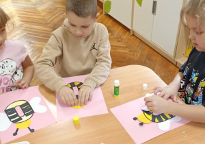dzieci kolorują literę o i doklejają elementy